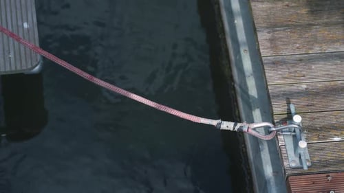 festgemachte Yachten und Boote. Nahaufnahme eines Seils und eines Piers im Meer, in dessen Nähe Boote stehen