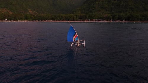 Outrigger Sailing Boat on Tropical Beach at Dusk