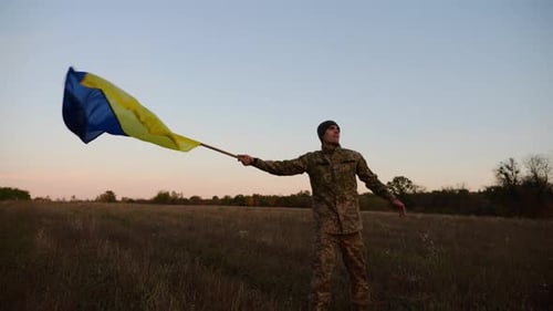 Young Soldier of Ukrainian Army Waving Blueyellow Banner on Liberated Territory Occupied By Russia