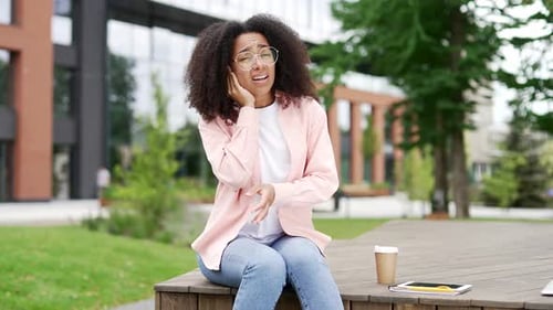 Young Woman Experiencing Ear Pain Outdoors