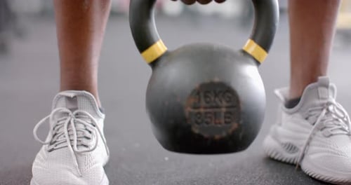 Vista aproximada de calçados esportivos e um kettlebell na academia