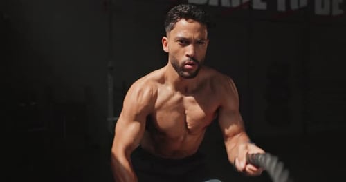 Man, battle rope and exercise athlete for gym performance or muscle building with arm workout