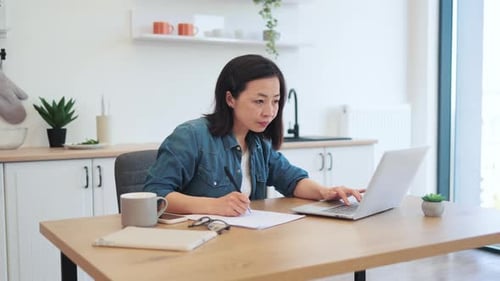 Woman Working from Home in Kitchen