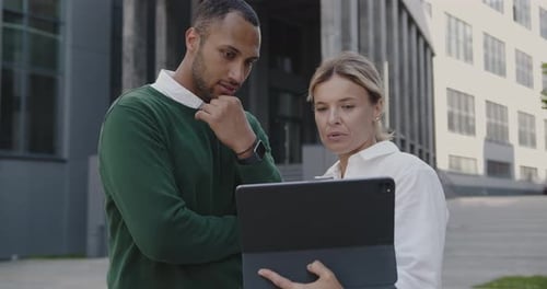 Woman and Man Discussing Tablet Outside Office