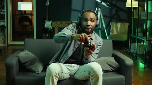 Enthusiastic Gamer Plays Video Game on Sofa