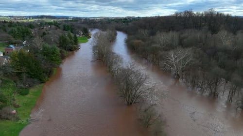 Aerial view showing flooded river with dirty water after heavy rain in USA suburbia.