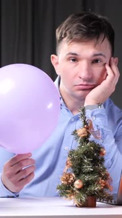 Vertical Video Office Worker Bored at Work During Christmas Time Holding Balloon