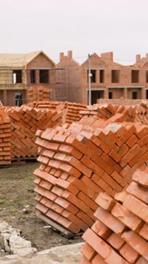 Townhouse Construction Site with Stacked Bricks and Foundations