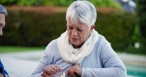 Chess, strategy and senior couple thinking while playing a board game in the garden of their home
