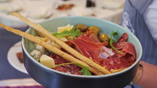 Board with Delicious Slices of Prosciutto and Salami Cheese Olives Arugula