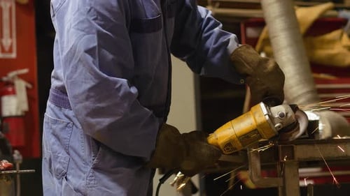Schweißer mit Schleifwerkzeug auf Metall in der Werkstatt 10 Sekunden oder länger