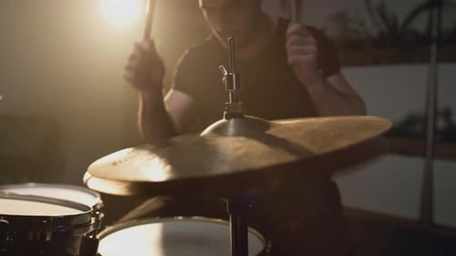 A Young Attractive Male Drummer Plays with a Stick on a Drum Set