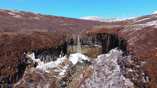 Striking Waterfall Cascading Over Basalt Columns in Winter
