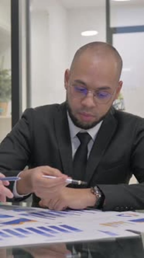 Young Businessmen Discussing Paperwork in Office, vertical video