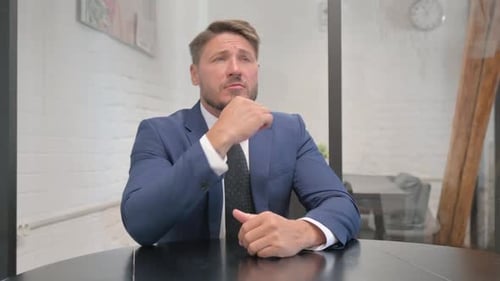Pensive Mature Adult Businessman Brainstorming New Idea at Work