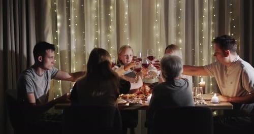 Family Gathering Together at Warm Dinner Table