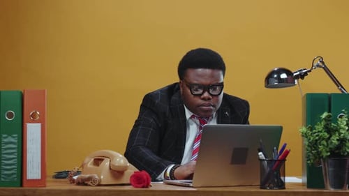 A Professional Man Works Diligently at His Desk with a Laptop Focused on Achieving Success