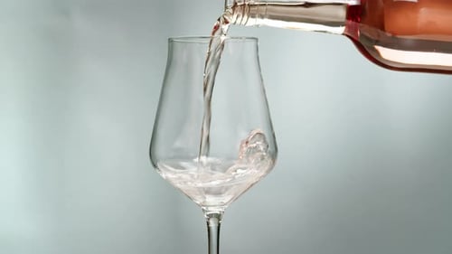 Orange or White Wine Bottle and Glass Against a Sunset in a Peaceful Vineyard Pouring of Ecological