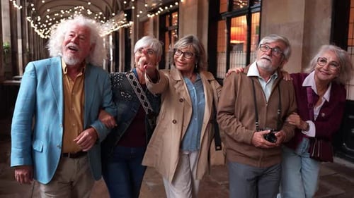 Five Happy Senior Friends Walking and Pointing in a City at Night