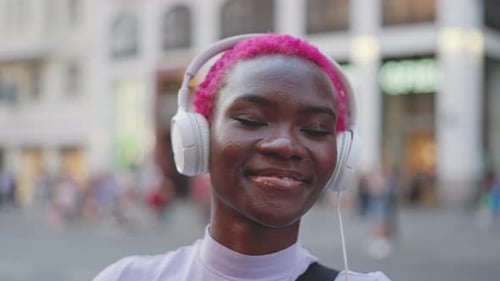 Woman Smiling While Listening to Music on Headphones
