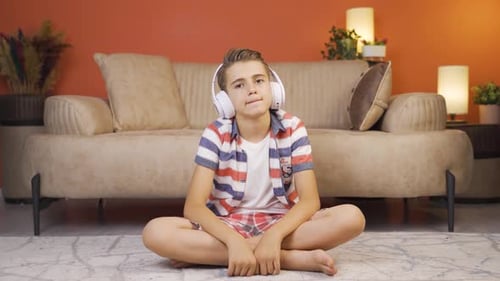 Junge hört zu Hause Musik mit Kopfhörern
