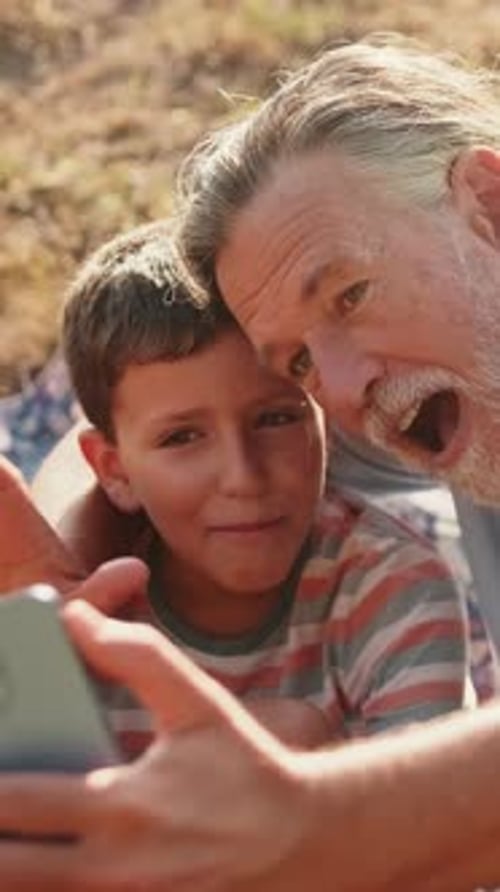 Grandfather and Grandson Video Chatting on Smartphone