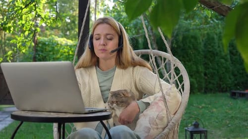 Woman works from home on laptop with cat