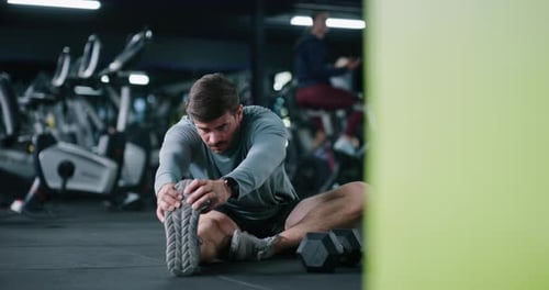 Ejercicio, estiramientos de piernas y hombre en el gimnasio para una rutina de acondicionamiento físico, entrenamiento o bienestar por la mañana