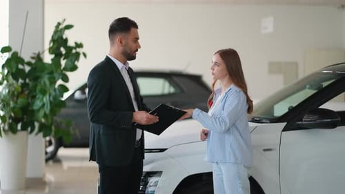 Car Salesman and Customer Shaking Hands by Car