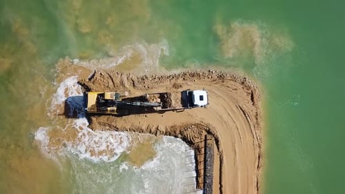 Bagger schöpft und entlädt Erde auf einen wartenden großen LKW