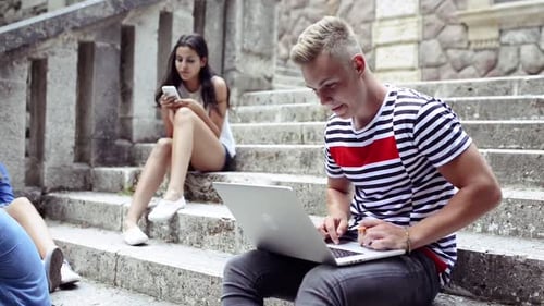 Students Using Technology and Relaxing on Stairs