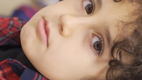 Vertical Video of Unhappy upset boy looking at camera.