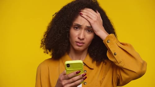 Woman Looking At Mobile Phone with Upset Expression