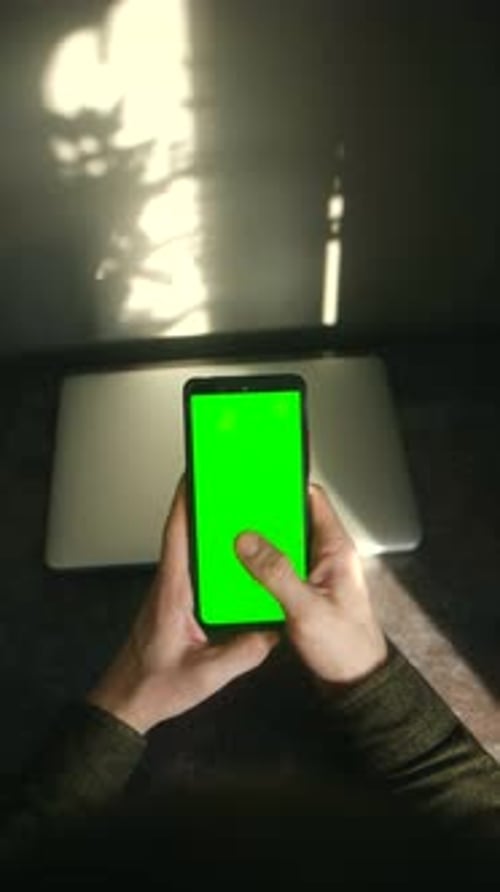Person Holding and Using Smartphone with Green Screen Mockup