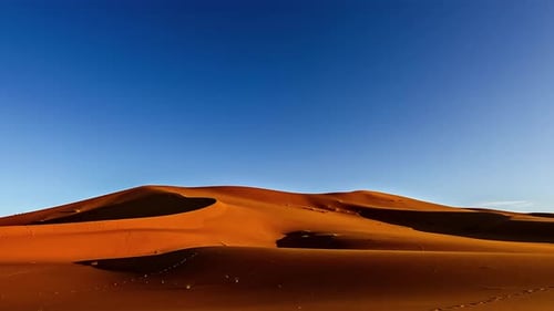 Timelapse video with orange sand dune on which it gets dark
