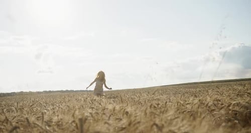Thrilled Young Woman Running in Wheat Field