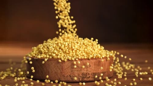Millet Falling into Wooden Bowl in Slow Motion