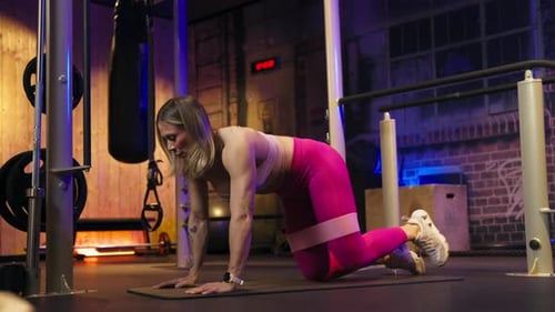Woman doing butt exercise with straps in the gym