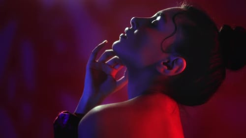 Elegant Woman Posing in Red and Blue Light