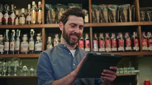 Smiling Business Owner Standing at Own Cafe and Using App on Digital Tablet