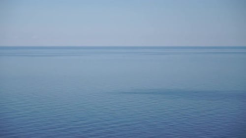 Panoramaaufnahme des wunderschönen Sonnenuntergangs über dem Meer, wunderschöne Meereslandschaft, Sonnenblendung, kleine Wellen auf dem