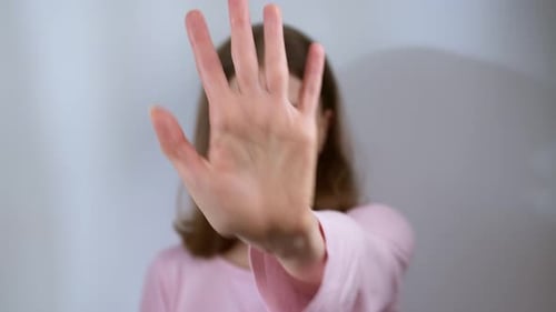 Eine Frau zeigt Stopp mit der Hand, um gegen Gewalt zu protestieren.
