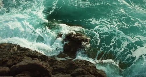 Ocean Waves Wash Over Rocky Shore Raging Sea Turquoise Water Foaming and Splashing Closeup Cinematic
