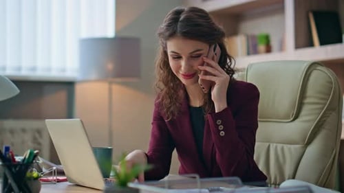 Woman Working on Laptop and Talking on Phone