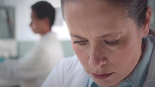 Woman Scientist Using Microscope in Modern Laboratory