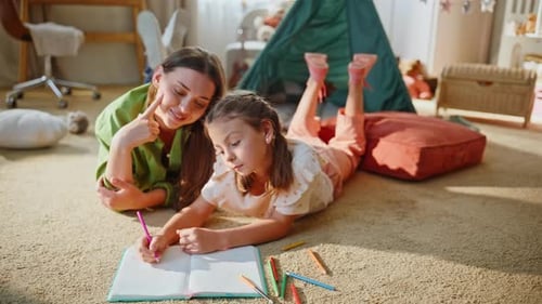 Woman and Girl Drawing Together in a Playroom