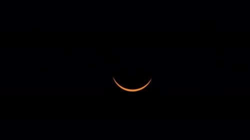 Eine schlanke Sonnensichel wird am Ende der Totalität während einer Sonnenfinsternis größer.