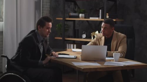Two Men in Business Suits are Looking at a Laptop Screen and Discussing Something Animatedly Office