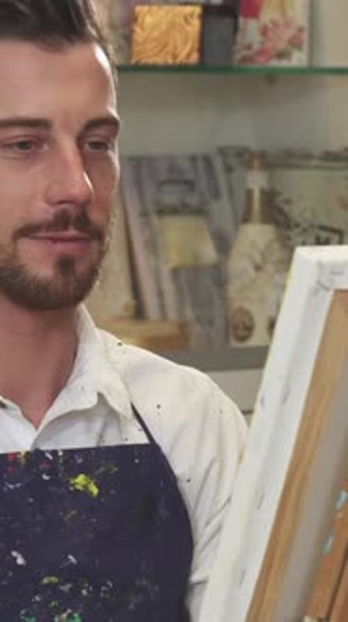 Passionate Bearded Male Artist Creating a Vibrant Masterpiece in His Colorful Studio