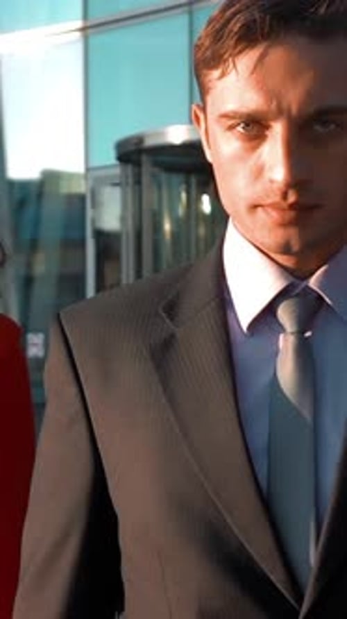 Fashionable Woman Walks with Man in Business Setting